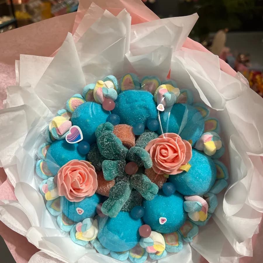 Bouquet de bonbons bleu et rose dans du papier de soie blanc et rose