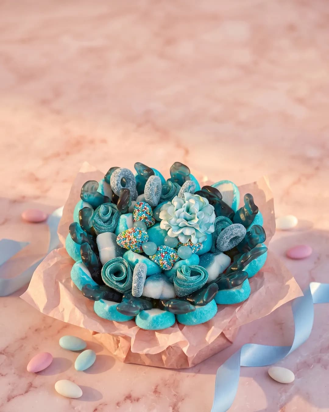 Bouquet de bonbons bleu et turquoise, mis en scène avec un ruban bleu